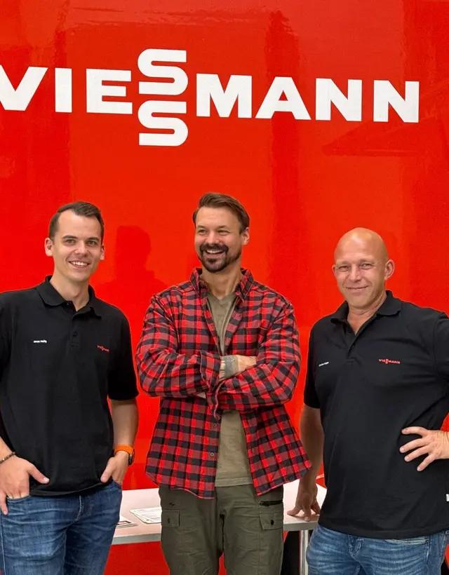 Felix Udo Werner in der Mitte, im rot karierten Hemd, mit zwei Viessmann-Kollegen vor dem Viessmann-Truck